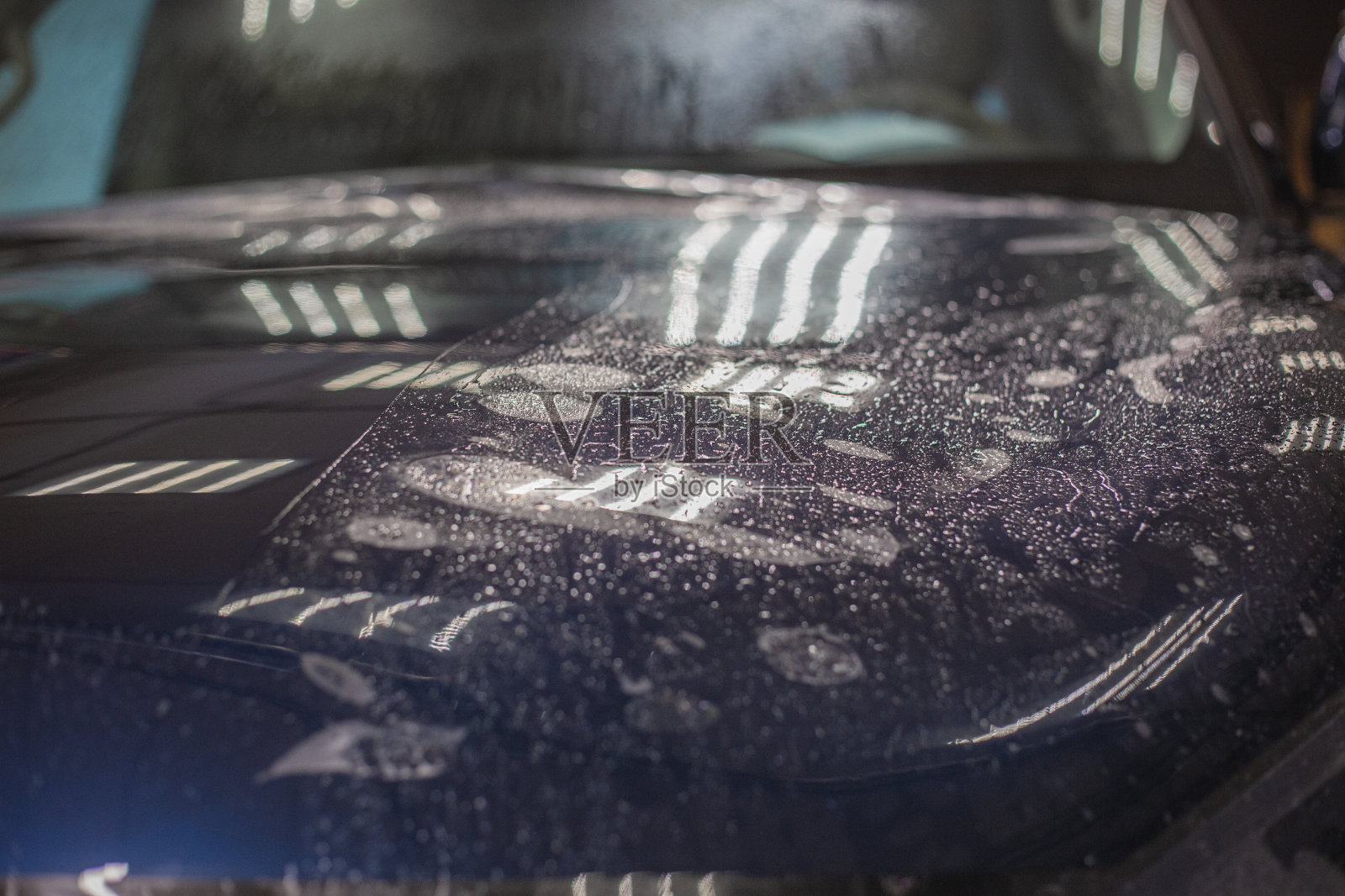 在汽车引擎盖上安装PPF的过程。PPF是一种油漆保护膜，可以保护油漆免受划痕和碎石的伤害。照片摄影图片