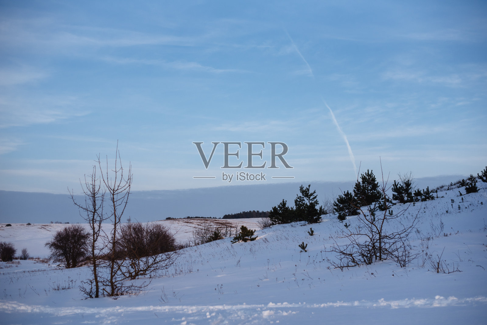 在自然公园，一个神奇的白色冬季日落的广角镜头。冬天日落。风景，白雪覆盖的田野在夕阳的光芒下。照片摄影图片