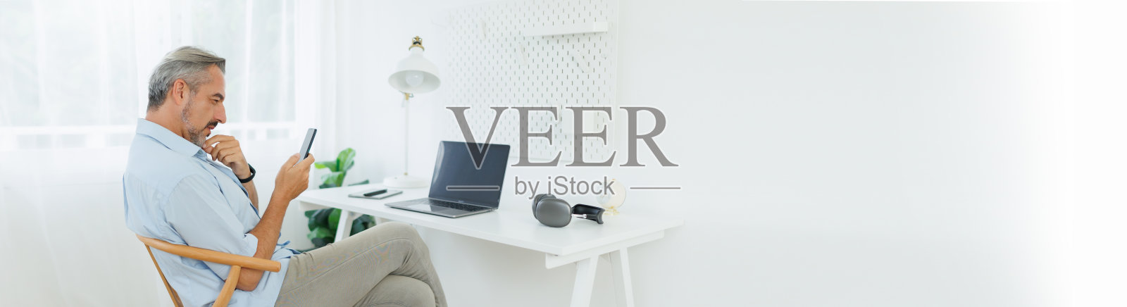 高级成熟成年男子使用手机和笔记本电脑照片摄影图片