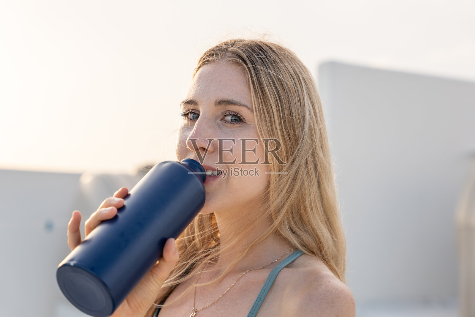 年轻女子用可重复使用的瓶子喝水的肖像照片摄影图片