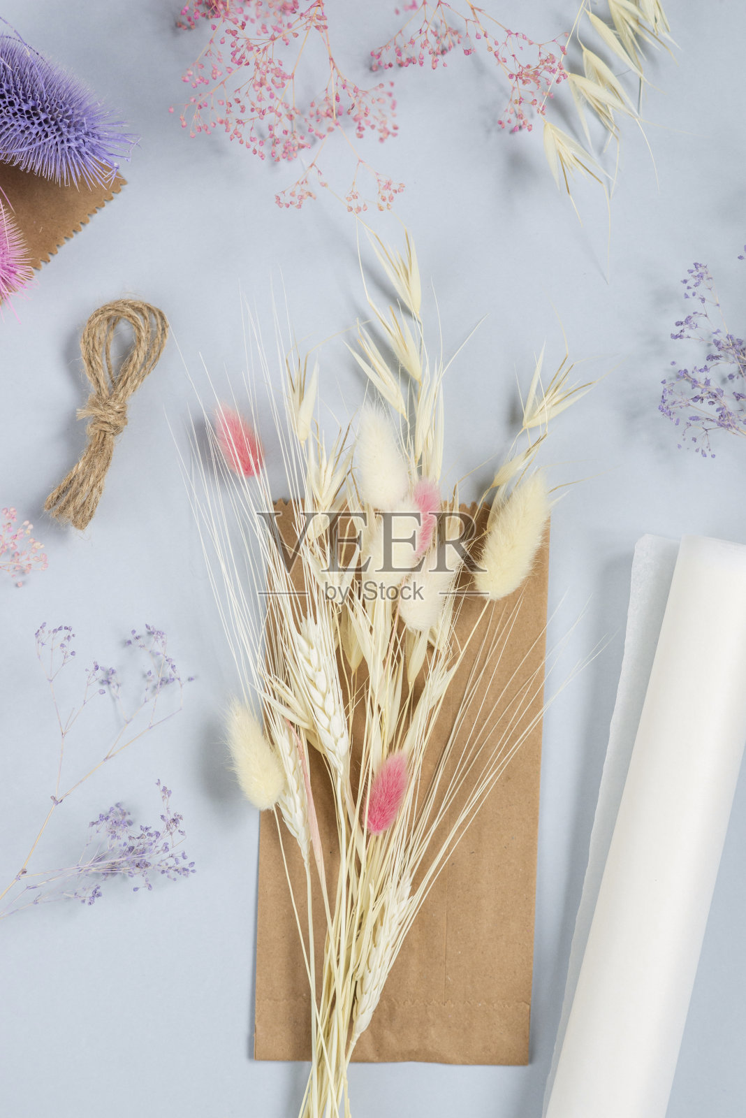 基本设置为简单的自制漂亮的粉色干花束在大师班。一个爱好，生意的想法。在灯光背景下制作长立花的时尚生态diy照片摄影图片