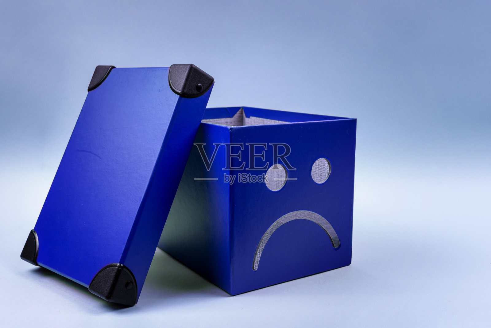 蓝色星期一的概念。蓝盒子上有一张悲伤的脸。空脑袋的概念。照片摄影图片