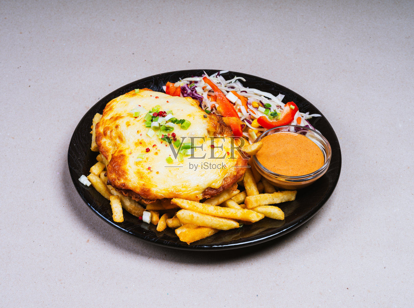 美味的新鲜准备的食物在美丽的黑色盘子..炸薯条、乳酪肉排和凉拌卷心菜。照片摄影图片