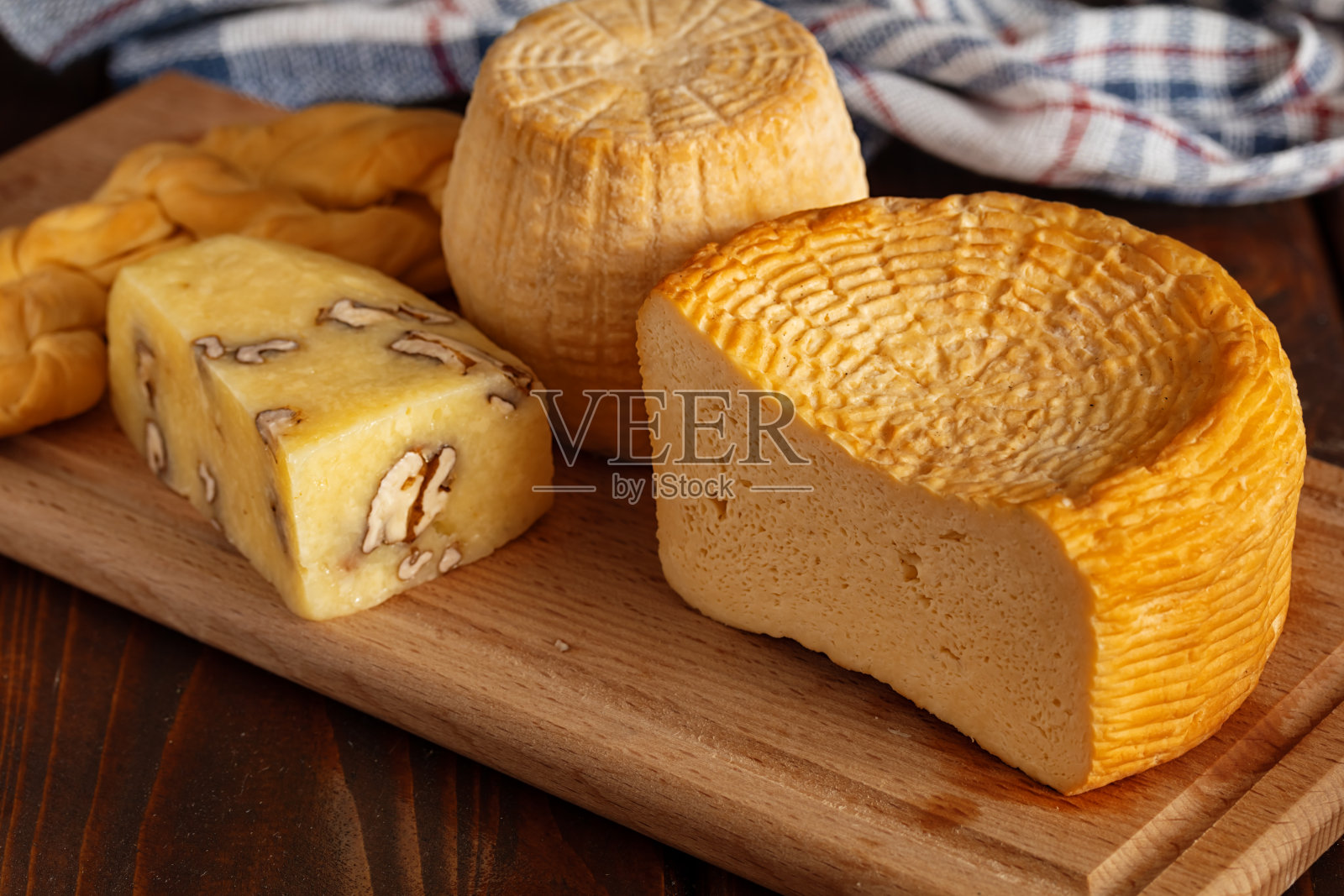 自制的奶酪轮子放在木桌上。照片摄影图片