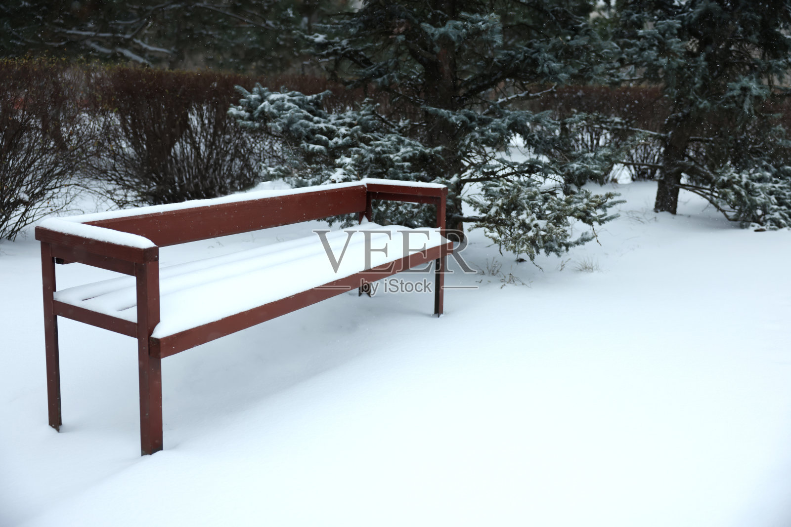 城市公园里被雪覆盖的长凳照片摄影图片