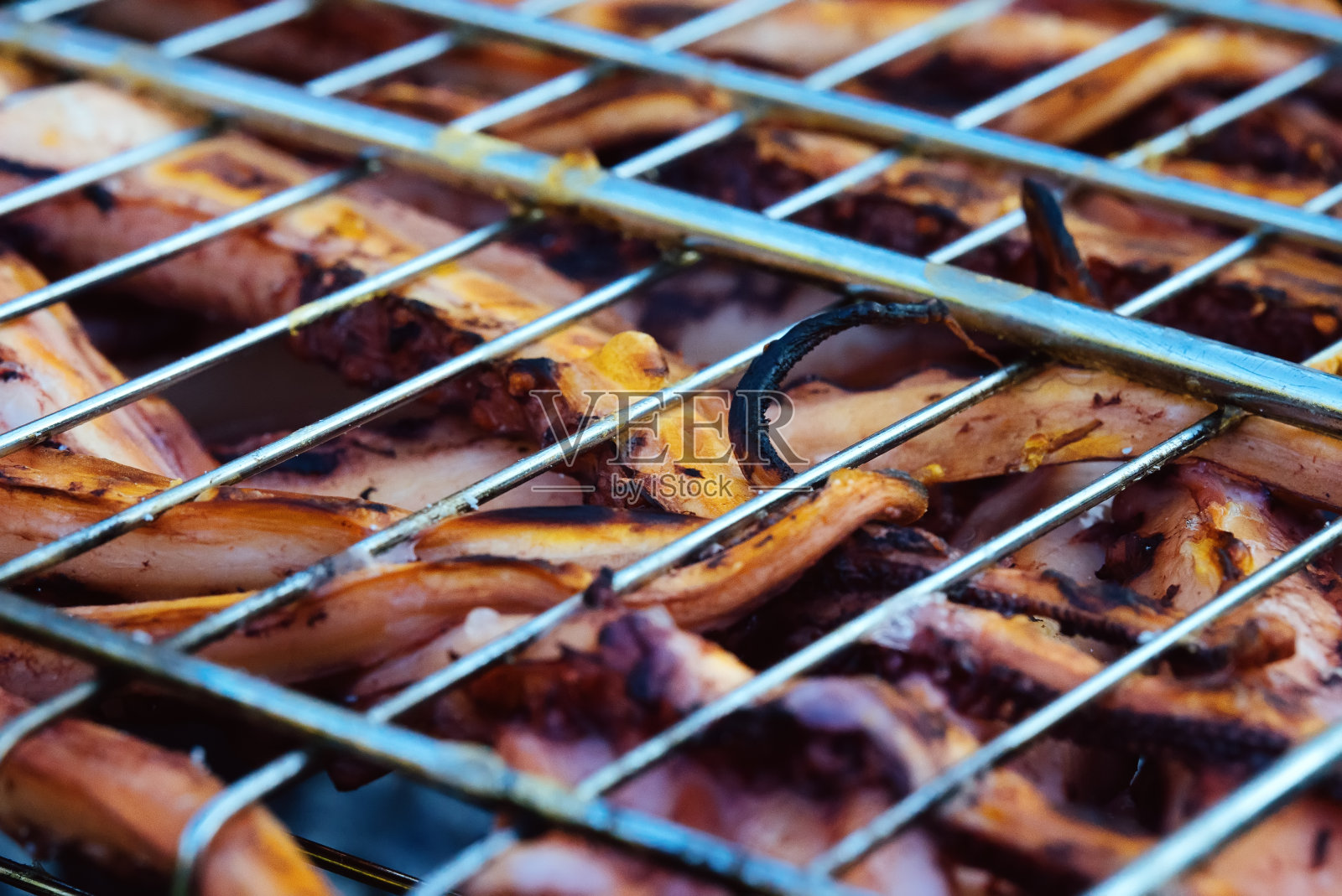 章鱼的触须是在烤架上烤的。照片摄影图片
