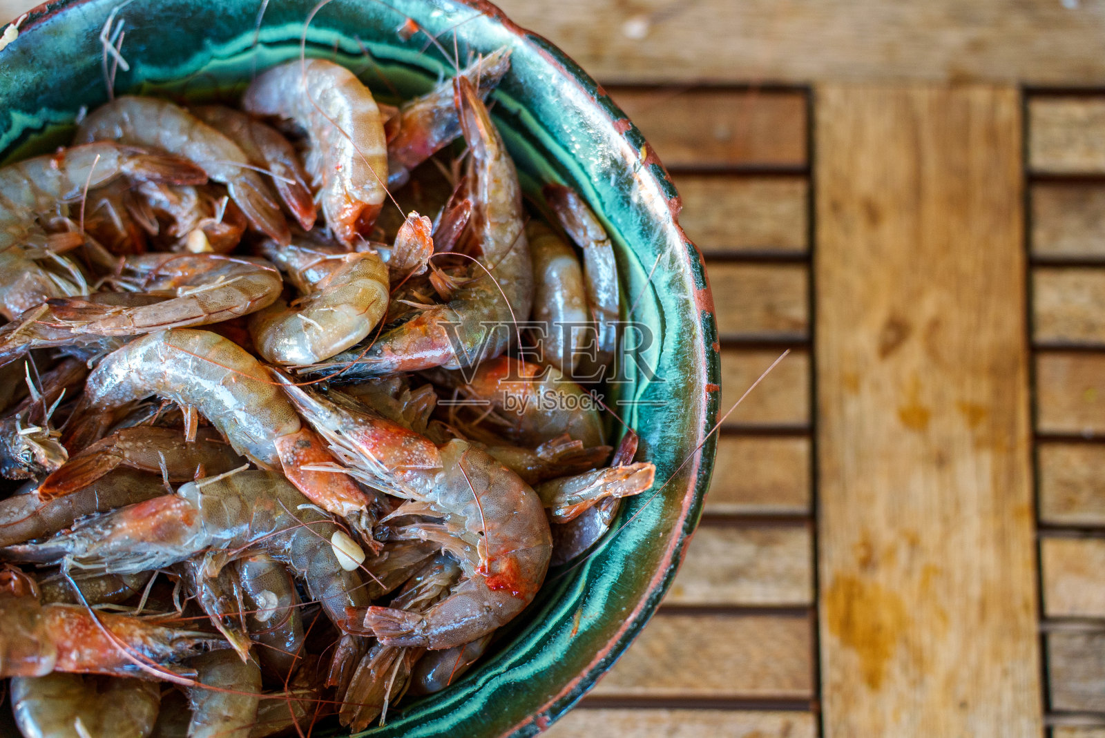 盛在碗里待煮的鲜虾。照片摄影图片