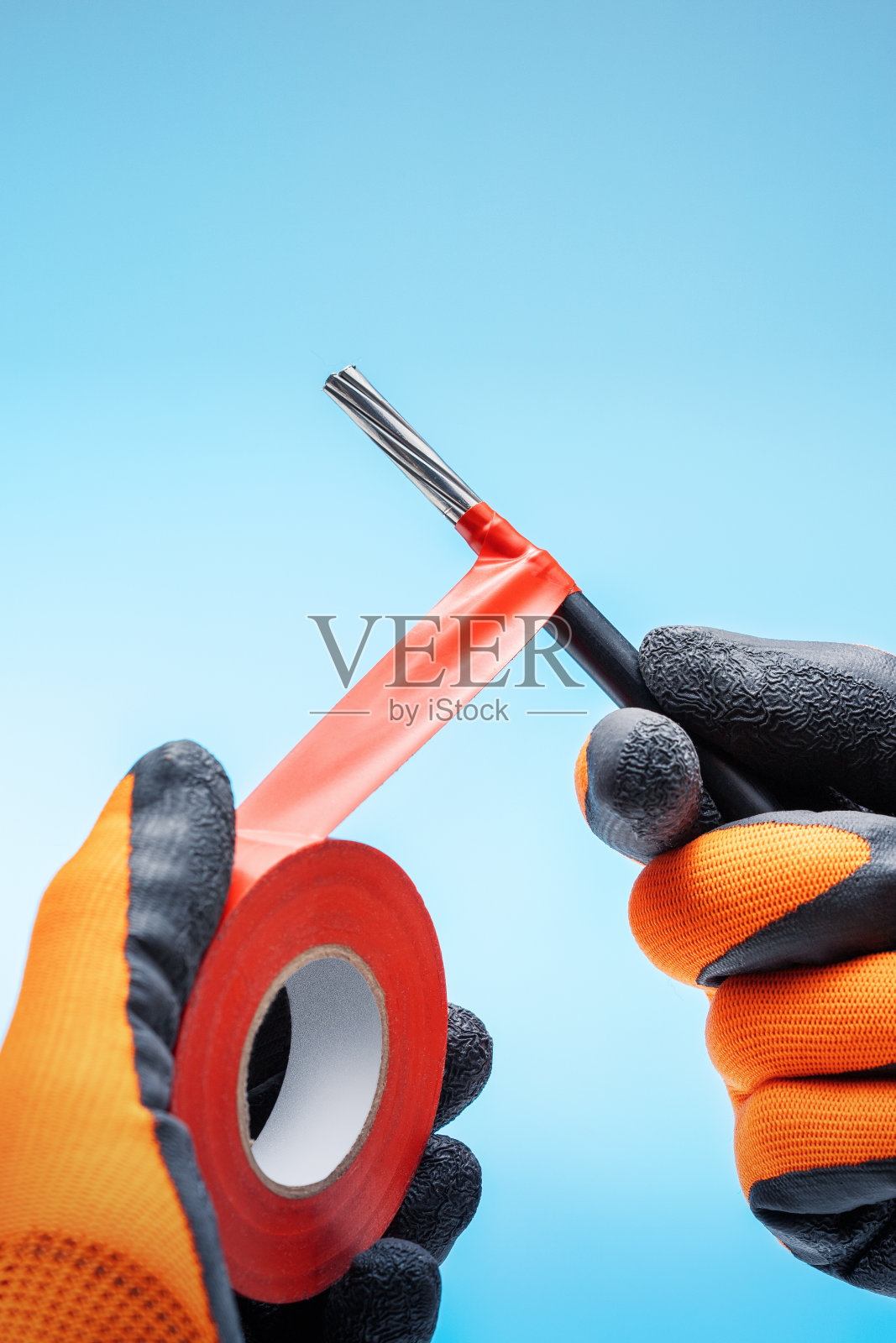 从事电缆布线工作的电工。电工使用绝缘胶带。照片摄影图片