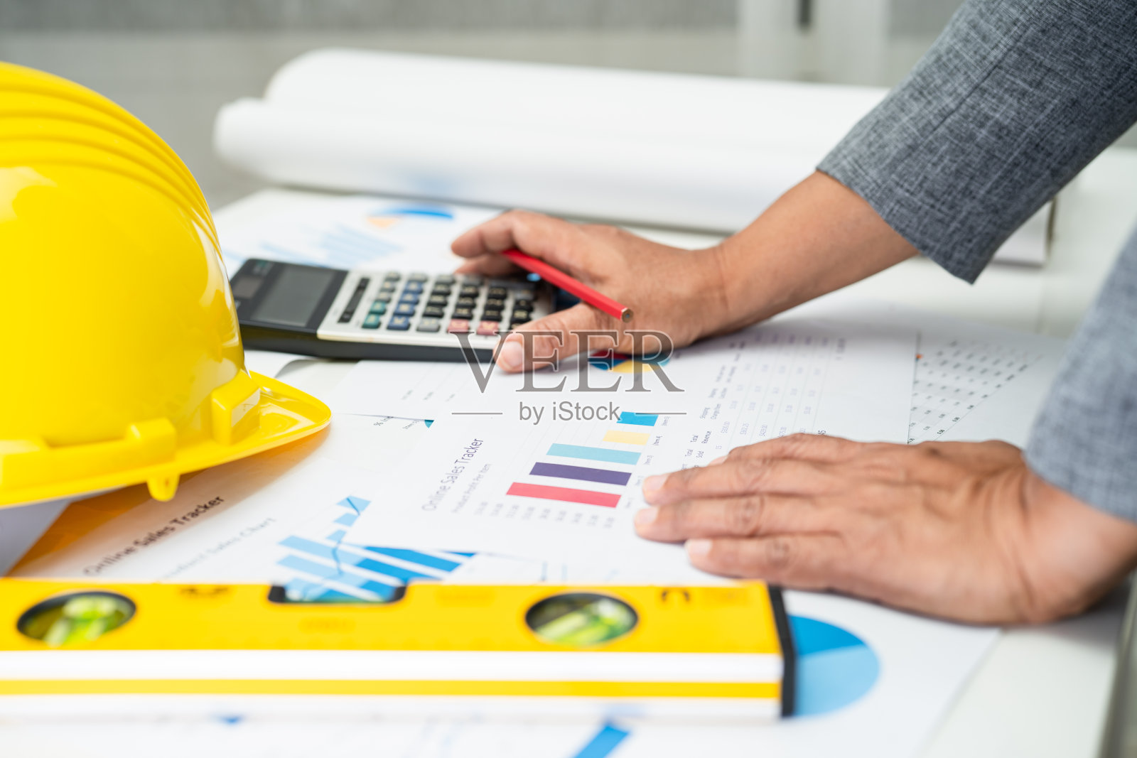 亚洲工程师，有建筑房屋平面图，工程蓝图，图和黄色头盔和工程施工工具。照片摄影图片