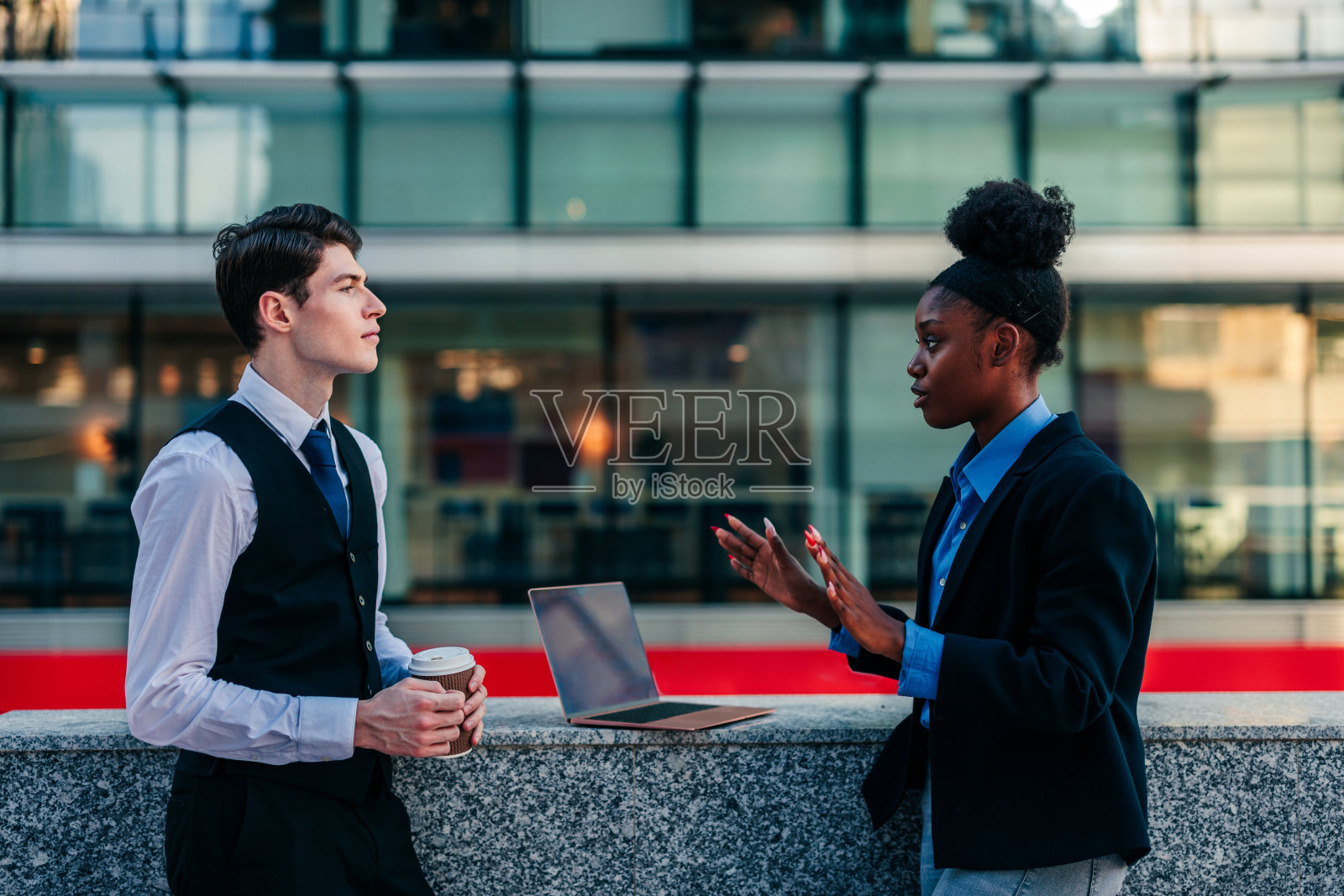 办公室职员在办公大楼外讨论业务照片摄影图片