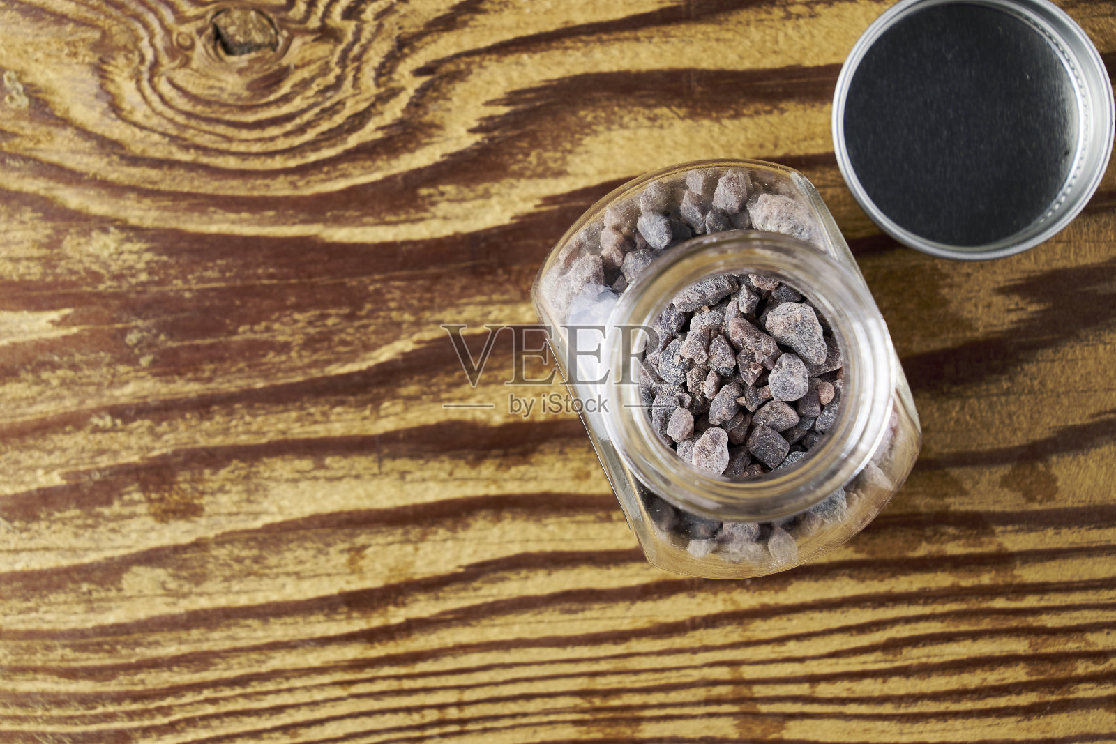 黑盐卡拉纳麦放在玻璃盐瓶里，木桌上有一个复制空间照片摄影图片