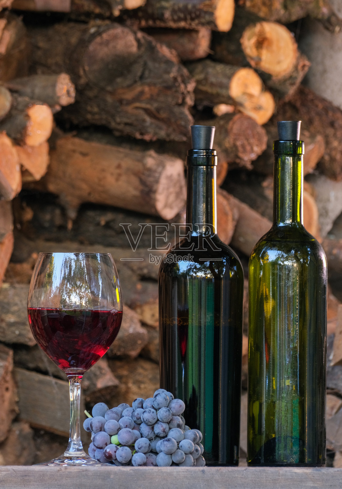 玻璃杯里的红酒。品酒和酿酒概念。在酒庄品尝伊莎贝拉葡萄酿制的家乡红酒。葡萄酒侍酒师将葡萄酒甜品倒入室外葡萄园的玻璃杯中照片摄影图片