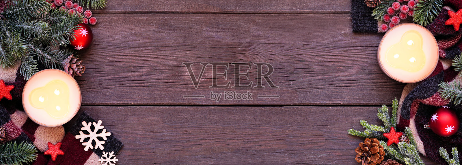 舒适的圣诞或冬季双边框红色，黑色和米色的毛衣，蜡烛，树枝和装饰在深色的木质横幅背景照片摄影图片
