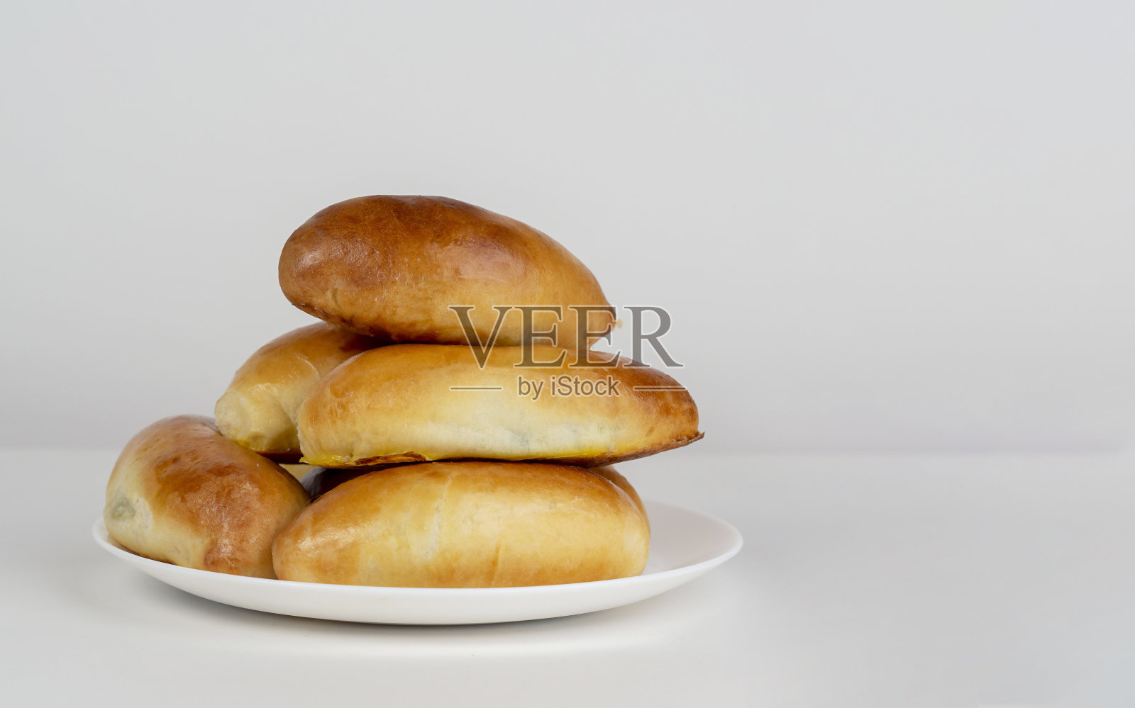 馅饼放在盘子里，背景很亮。自制食物的概念。照片摄影图片