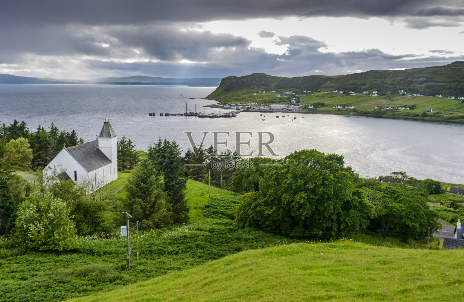 苏格兰教堂和起伏的绿色小山，俯瞰Uig海湾，斯凯岛，苏格兰，英国。照片摄影图片