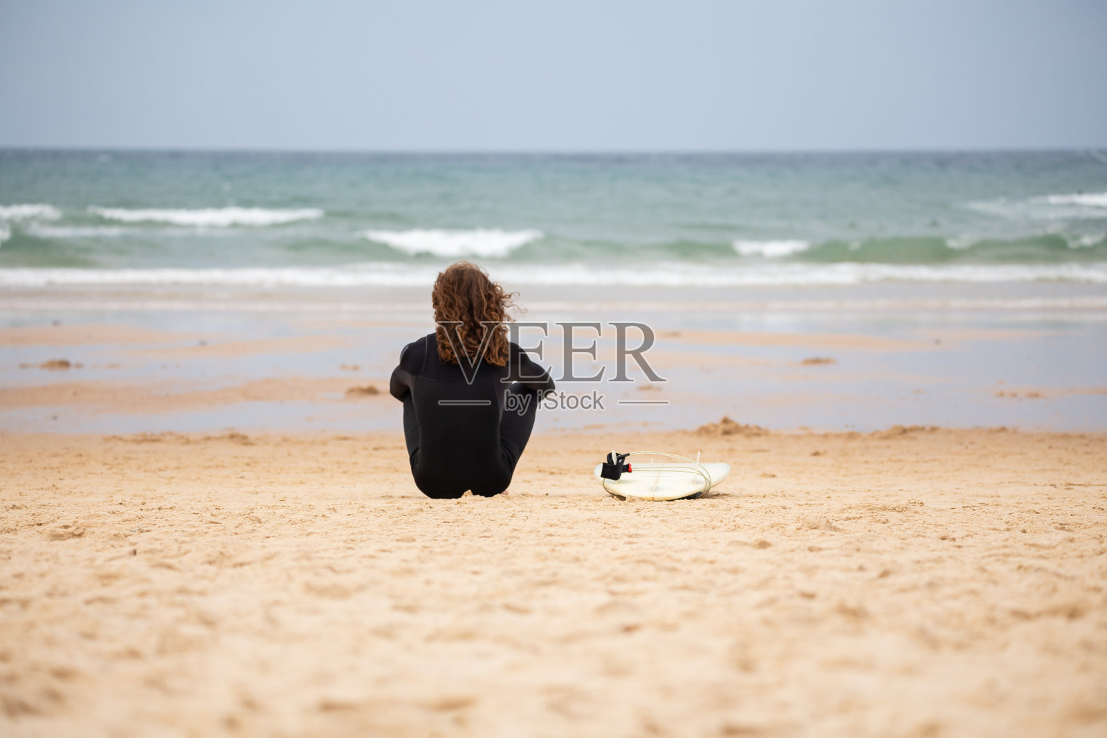 梦中男子坐在海滨冲浪板照片摄影图片