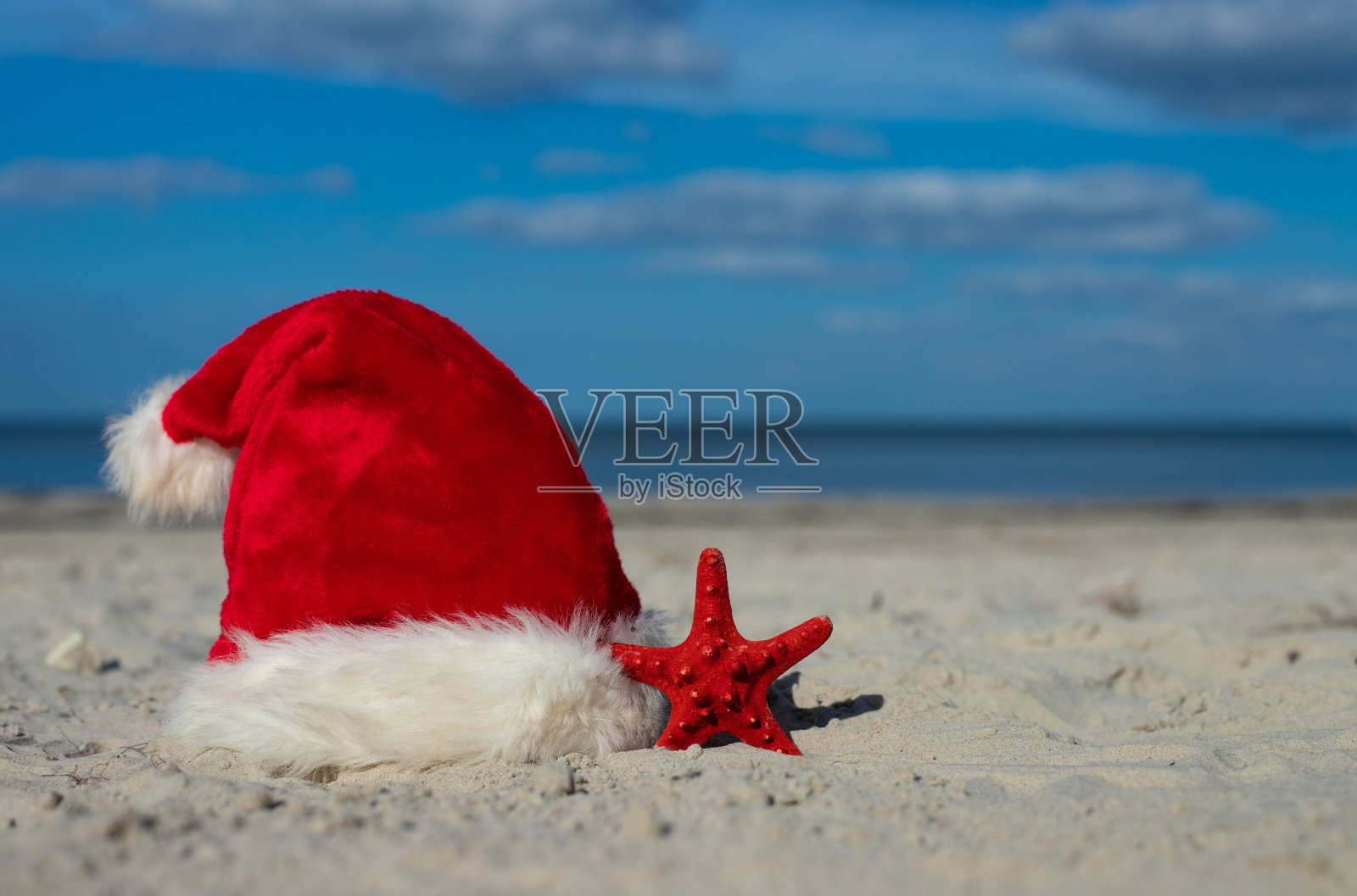 沙滩上的圣诞老人帽和海星照片摄影图片