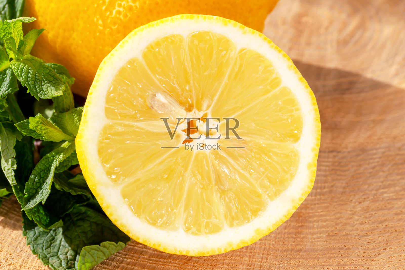成熟的柠檬和新鲜的薄荷在木制背景。特写镜头照片摄影图片