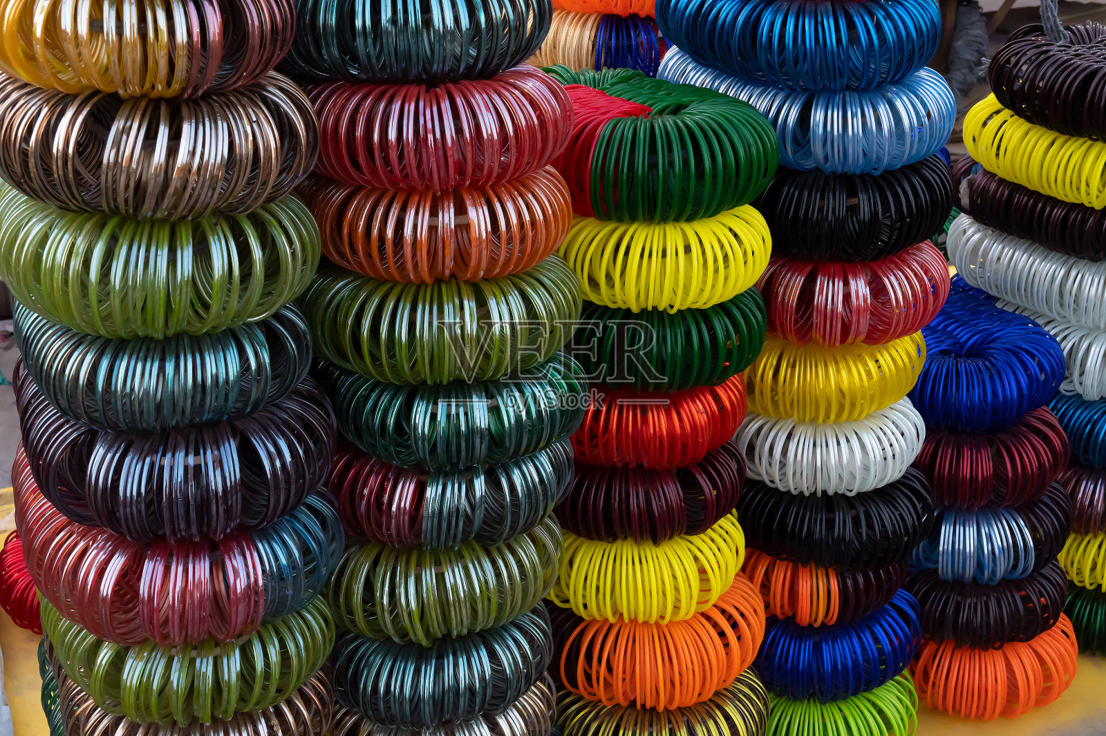 在印度拉贾斯坦邦焦特布尔著名的萨达尔市场和Ghanta ghar钟塔上出售的五颜六色的拉贾斯坦邦手镯。照片摄影图片