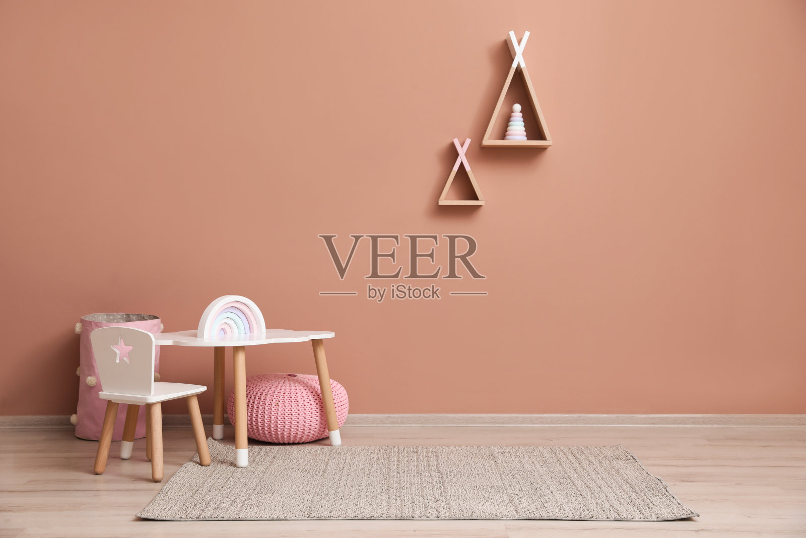 可爱的儿童房间内部有家具，玩具和粉色墙壁上的棚屋形状的架子照片摄影图片