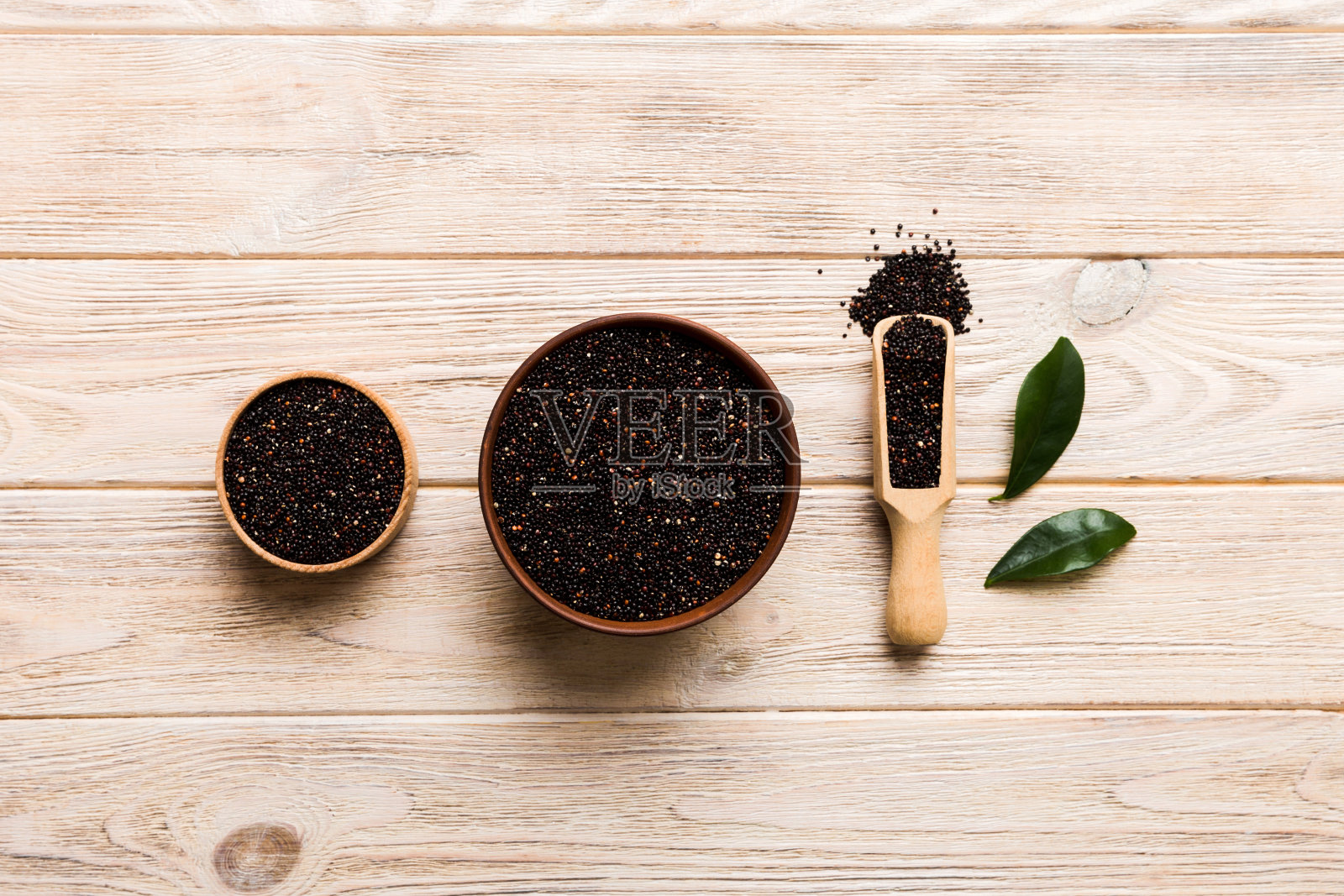 在碗和勺子里的藜麦种子在彩色背景上。健康的kinwa在小碗里。健康的超级食物照片摄影图片