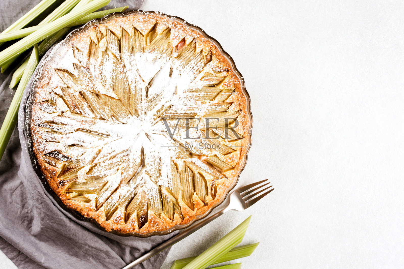 大黄派配上糖粉和大黄梗白色桌子与复制空间的文字。美味的自制糕点照片摄影图片