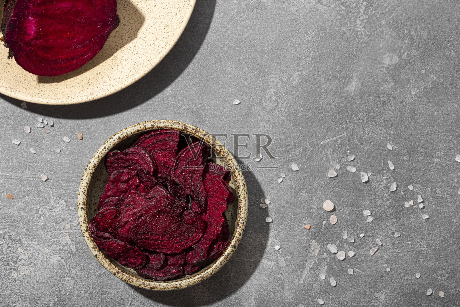 灰色背景下碗里的甜菜根片。健康的蔬菜薯片，素食者的零食俯视图复制空间的文字照片摄影图片