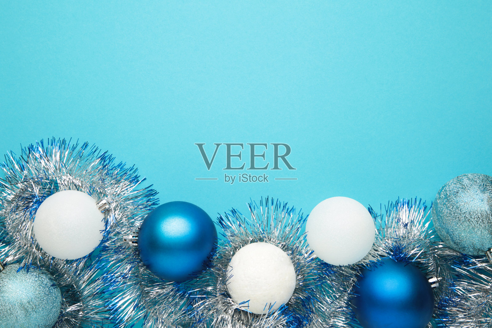 蓝色背景上有金属丝的圣诞球装饰。照片摄影图片