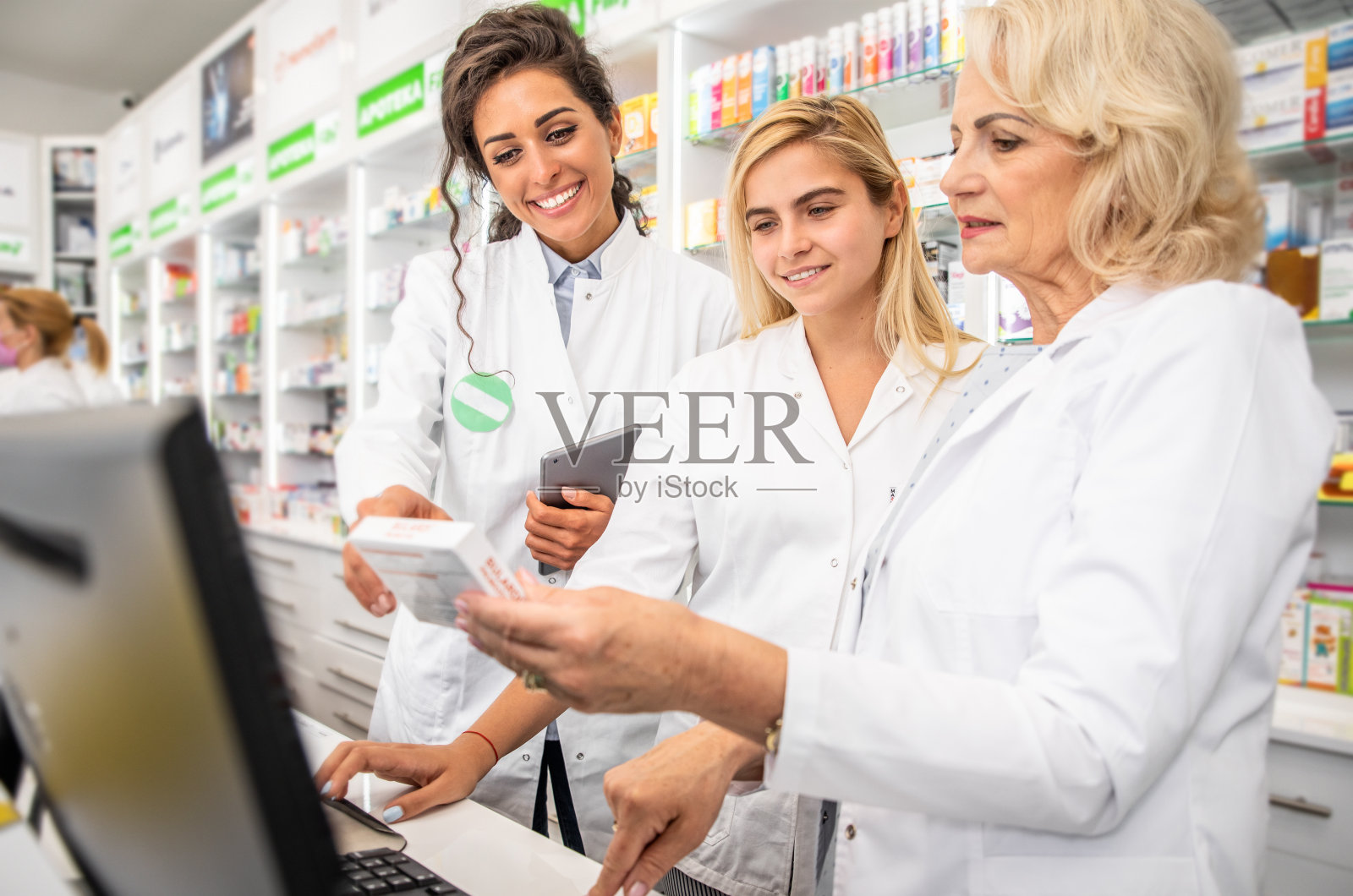 三名在药店工作的女药剂师。照片摄影图片