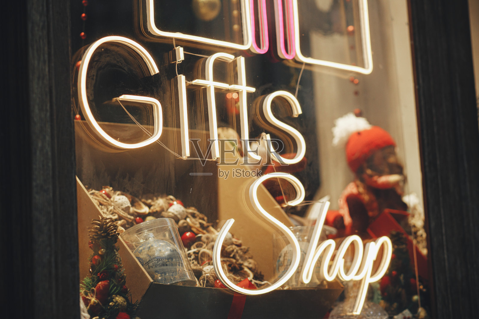 时尚的圣诞霓虹灯标志礼品店的建筑外观。城市街道上的现代圣诞装饰。在欧洲度寒假。圣诞快乐照片摄影图片