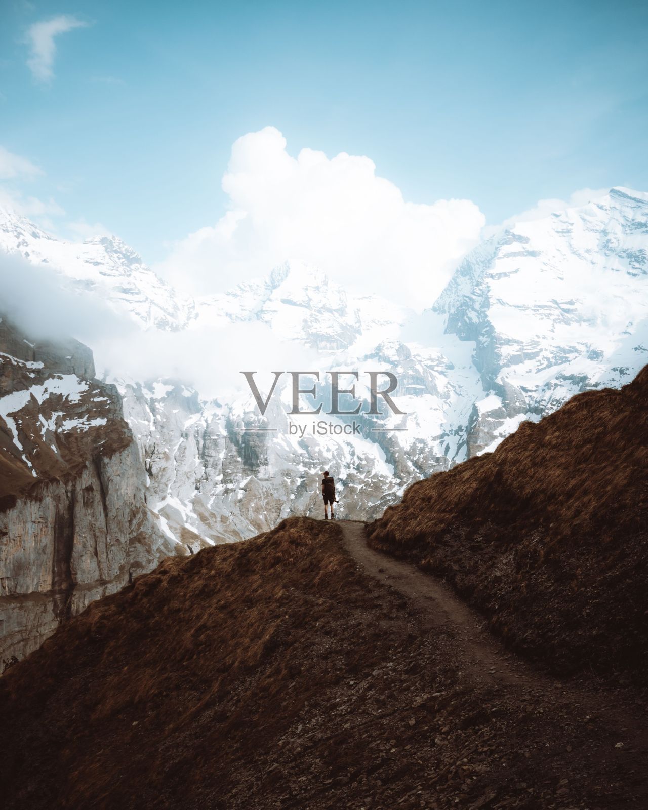 一个人在雪山中徒步的垂直镜头照片摄影图片