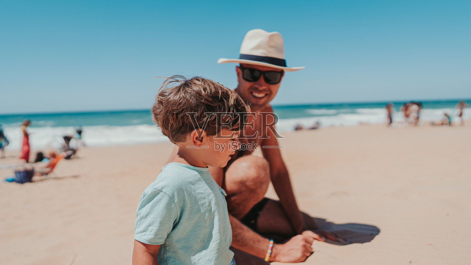 父亲和儿子在沙滩上快乐地玩耍照片摄影图片