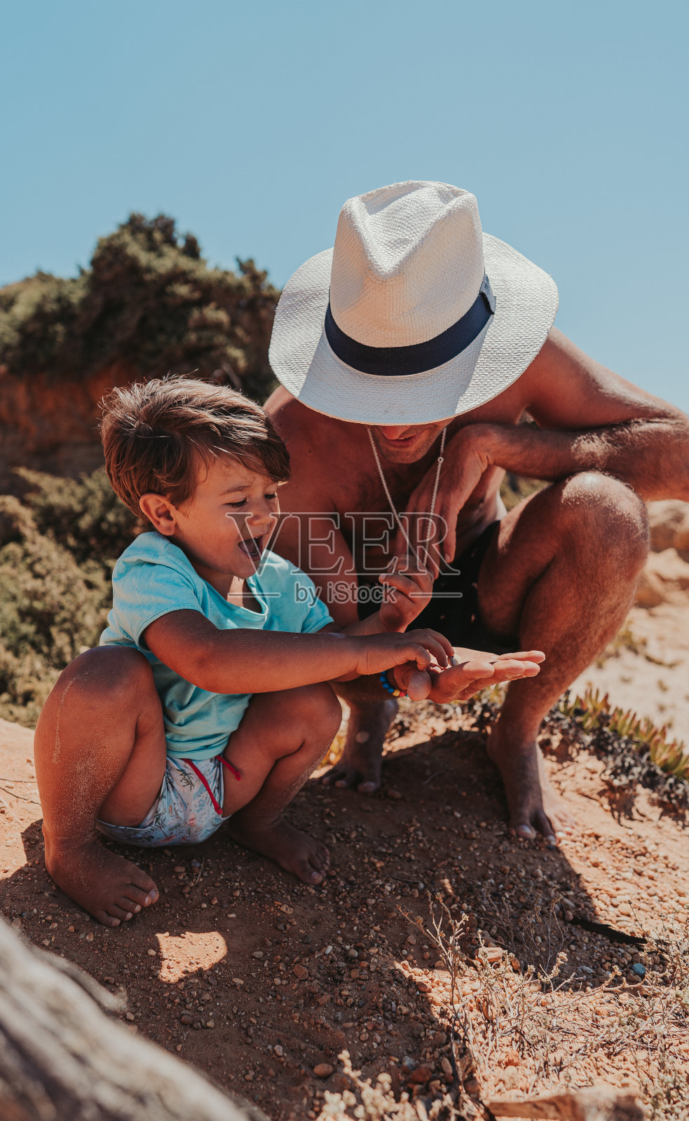 父亲和儿子在沙滩上快乐地玩耍照片摄影图片