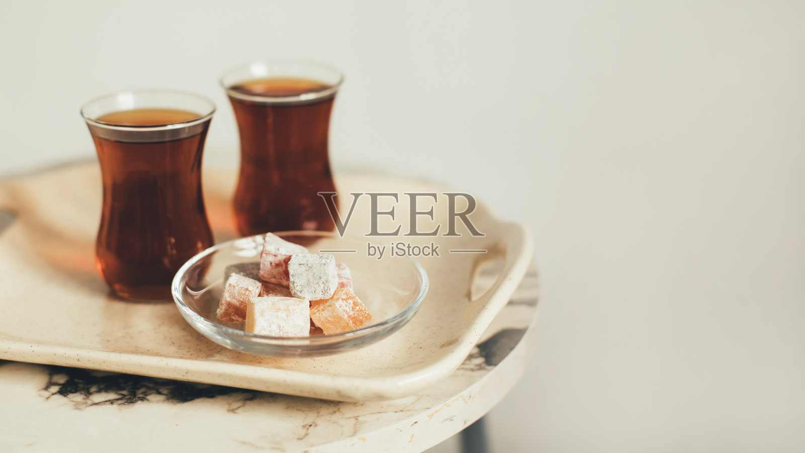 土耳其茶和甜点放在白色背景的托盘上。照片摄影图片