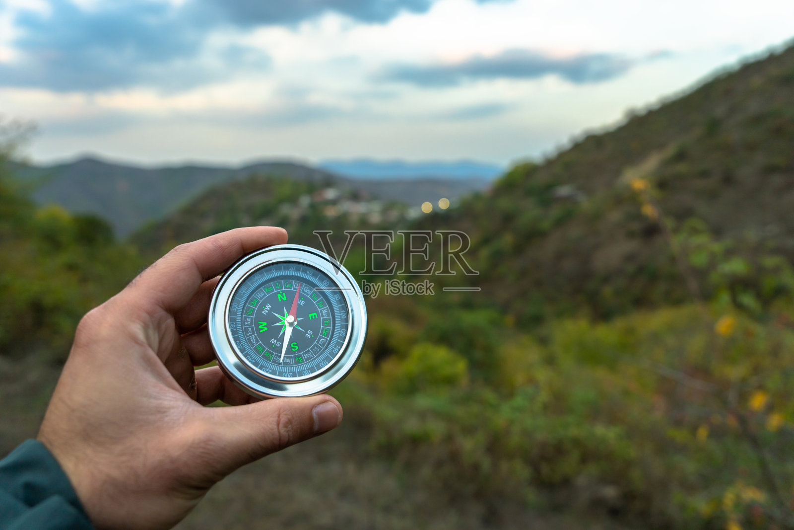 在森林的背景上拿着一个指南针照片摄影图片