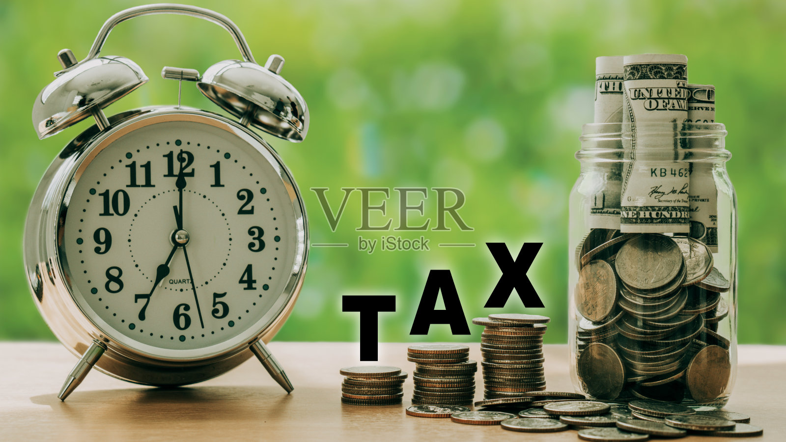 2023年交税。装有钱和硬币的玻璃钱箱。硬币堆上的税务信。照片摄影图片