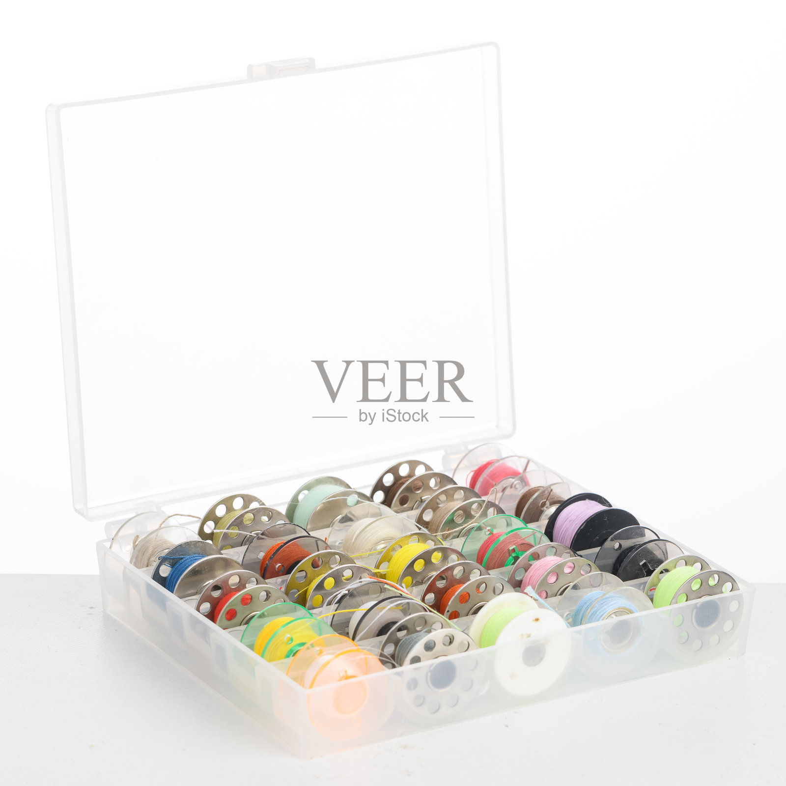 白色背景的缝纫机盒子里的一套金属线轴。侧视图照片摄影图片