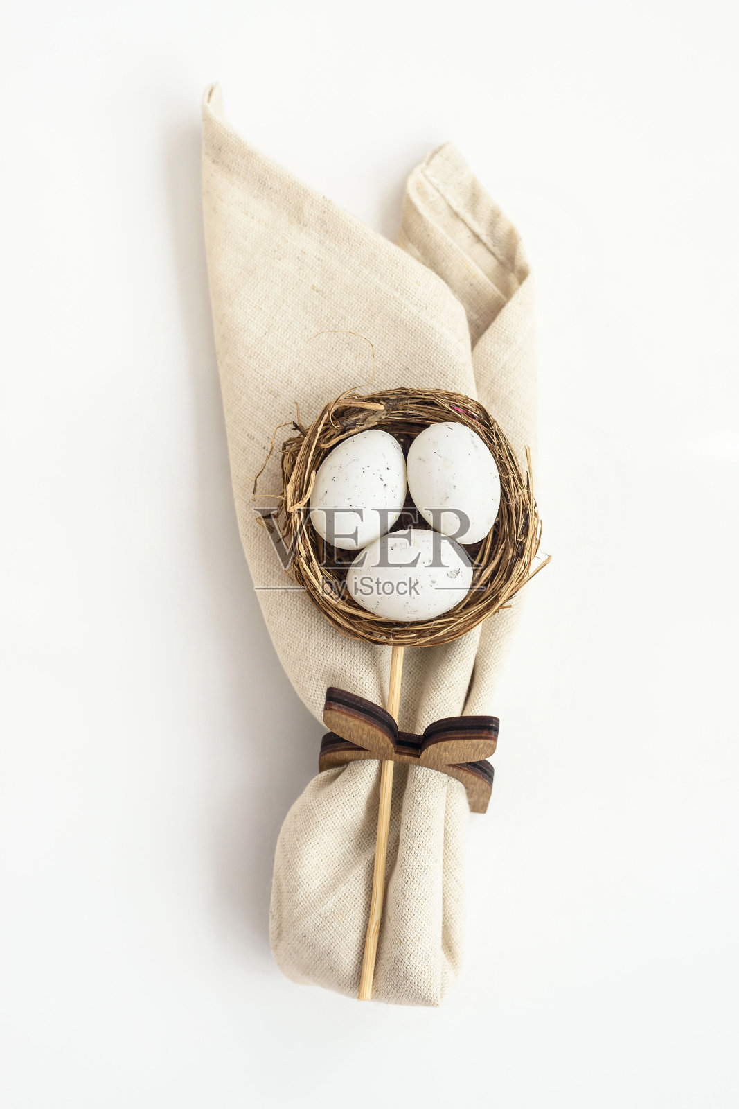 装饰柳条巢与鸡蛋和折叠餐巾在白色照片摄影图片