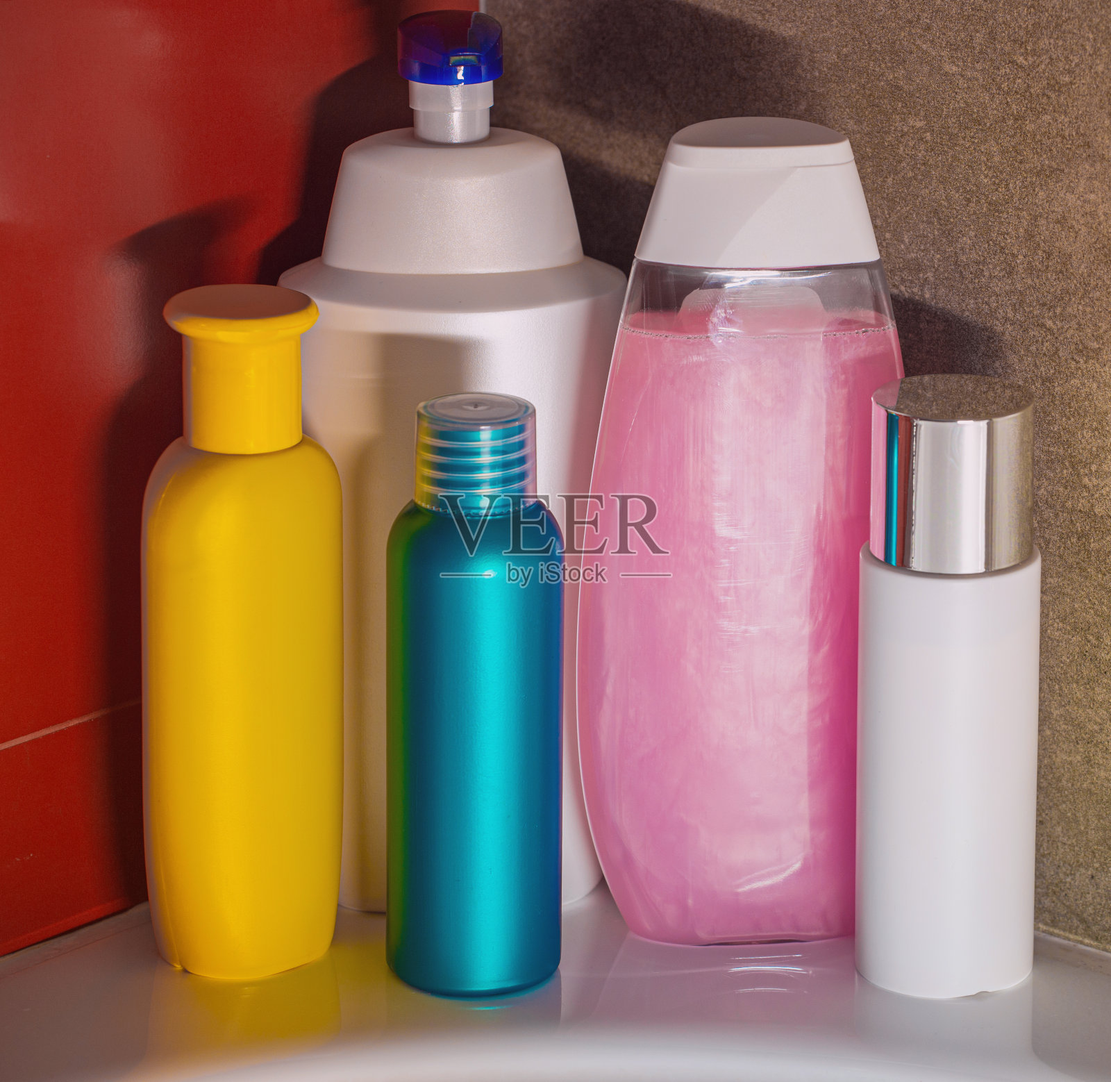 不同大小、形状和颜色的容器和瓶子，用于洗面奶、护发素、肥皂和洗发水。照片摄影图片