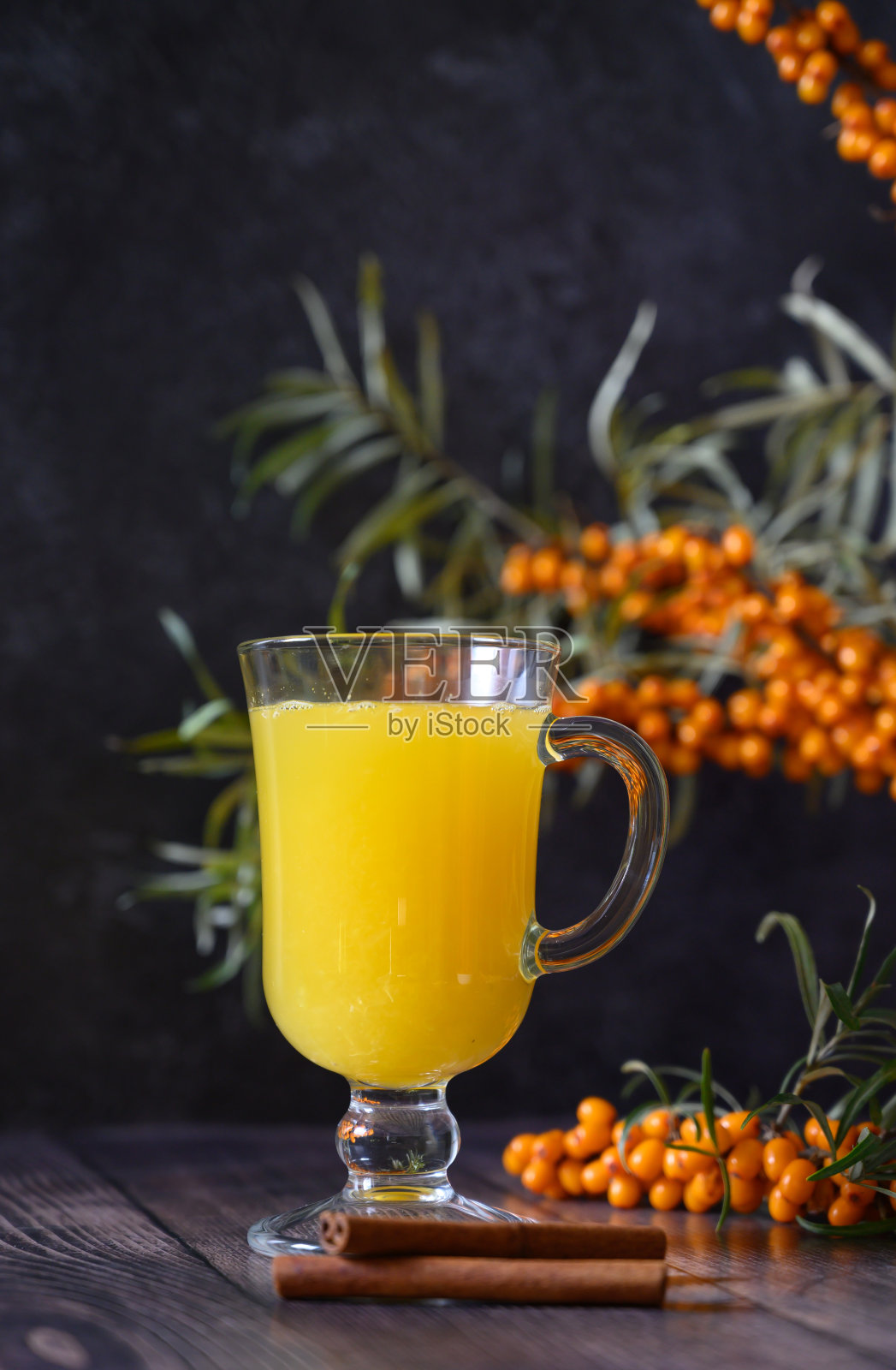 沙棘浆果茶与树枝在深色的木制背景照片摄影图片