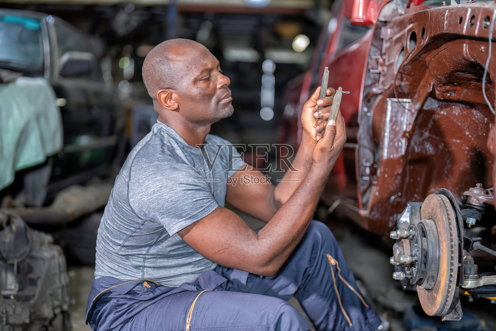 机械人坐着专心用扳手修理汽车照片摄影图片