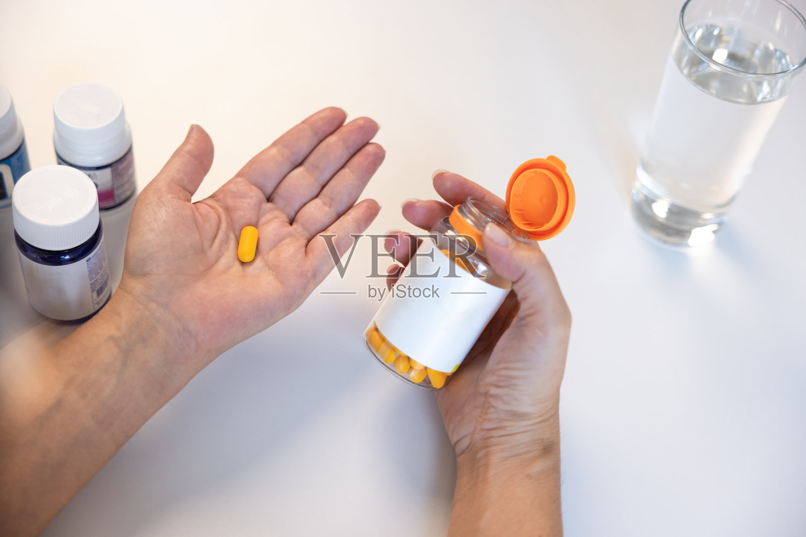 面目全非的女人，手掌上拿着药丸照片摄影图片