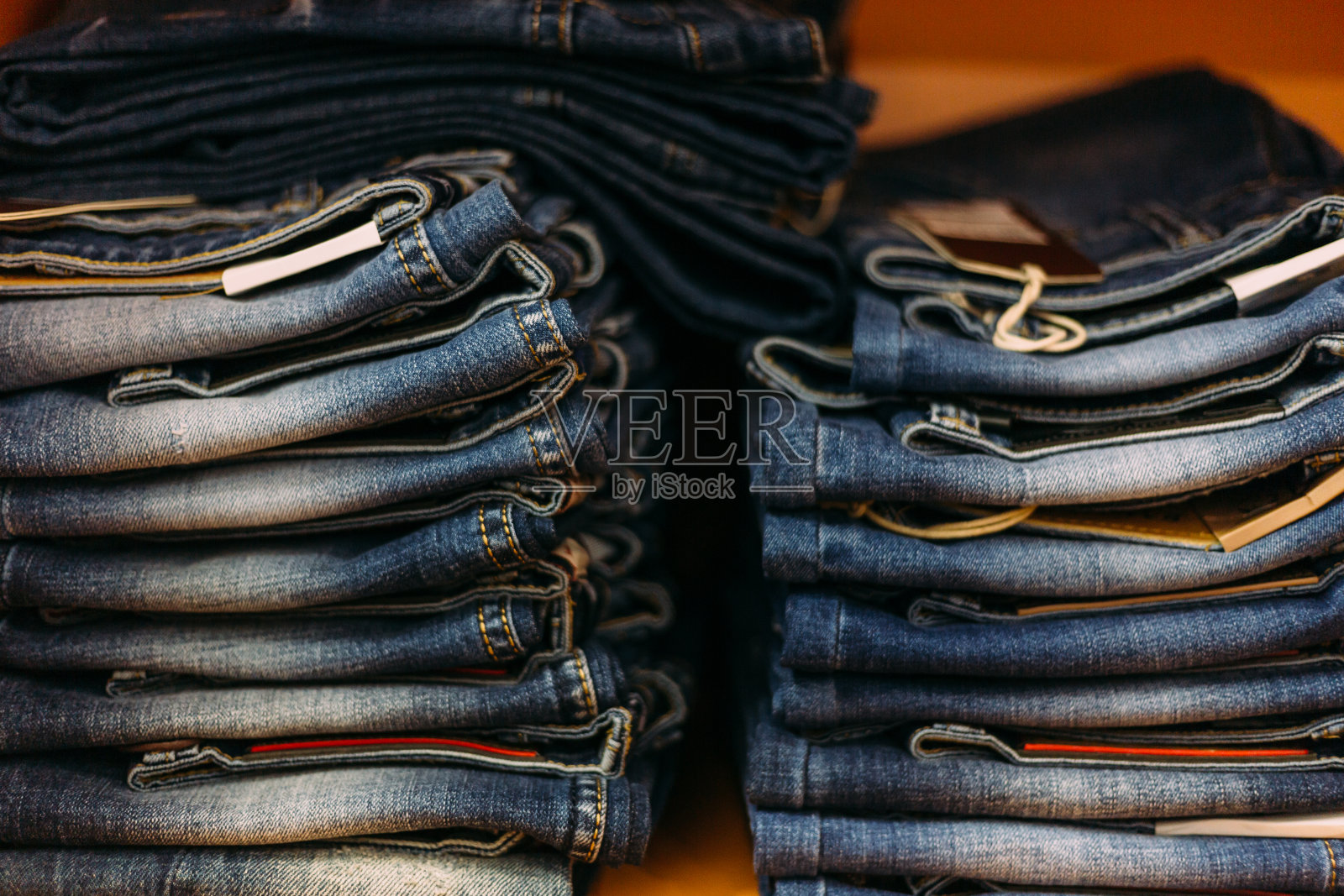 商店里一堆蓝黑相间的牛仔裤。购物概念和牛仔裤时尚。照片摄影图片