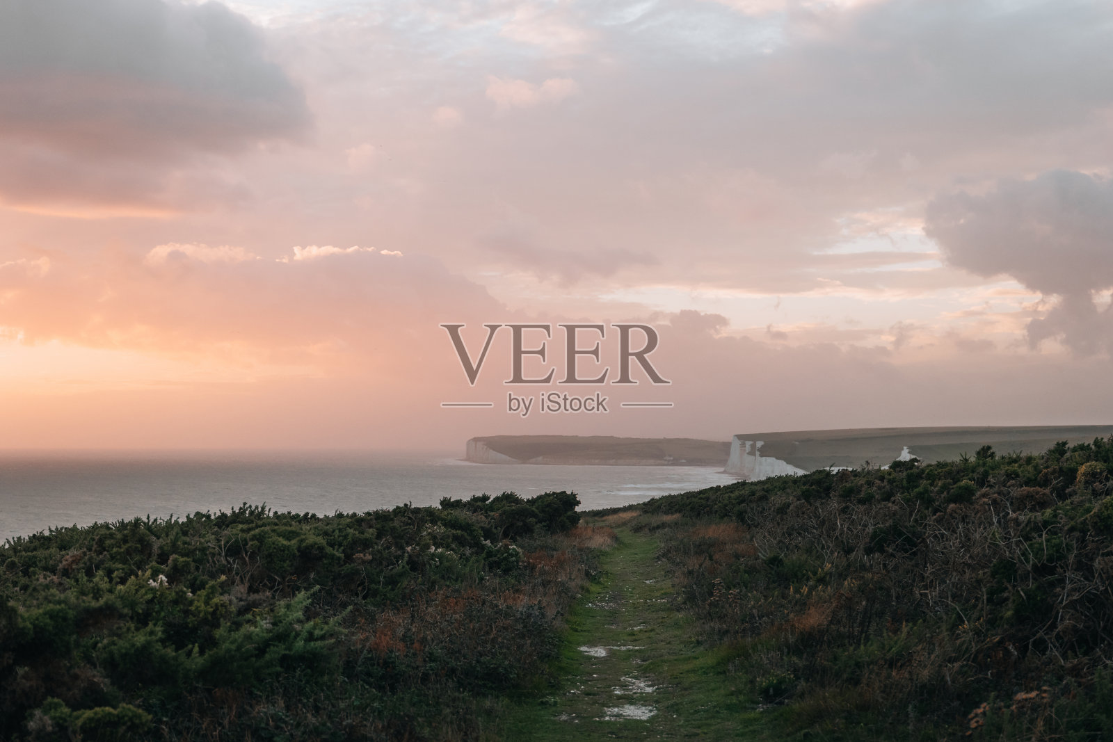 日落时分，英国东苏塞克斯七姐妹白垩崖的风景小径。照片摄影图片