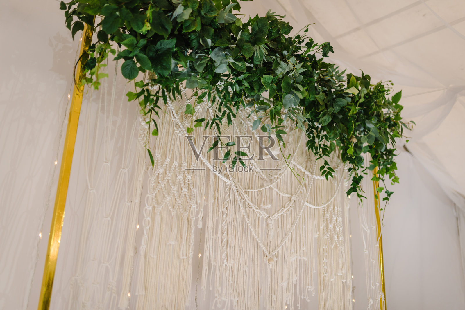 准备仪式。婚礼拱门装饰树叶桉树绿叶和花环与灯在帐篷。宴会厅用香草装饰。豪华典雅的墙面和装饰空间，还是拍照的好地方。照片摄影图片