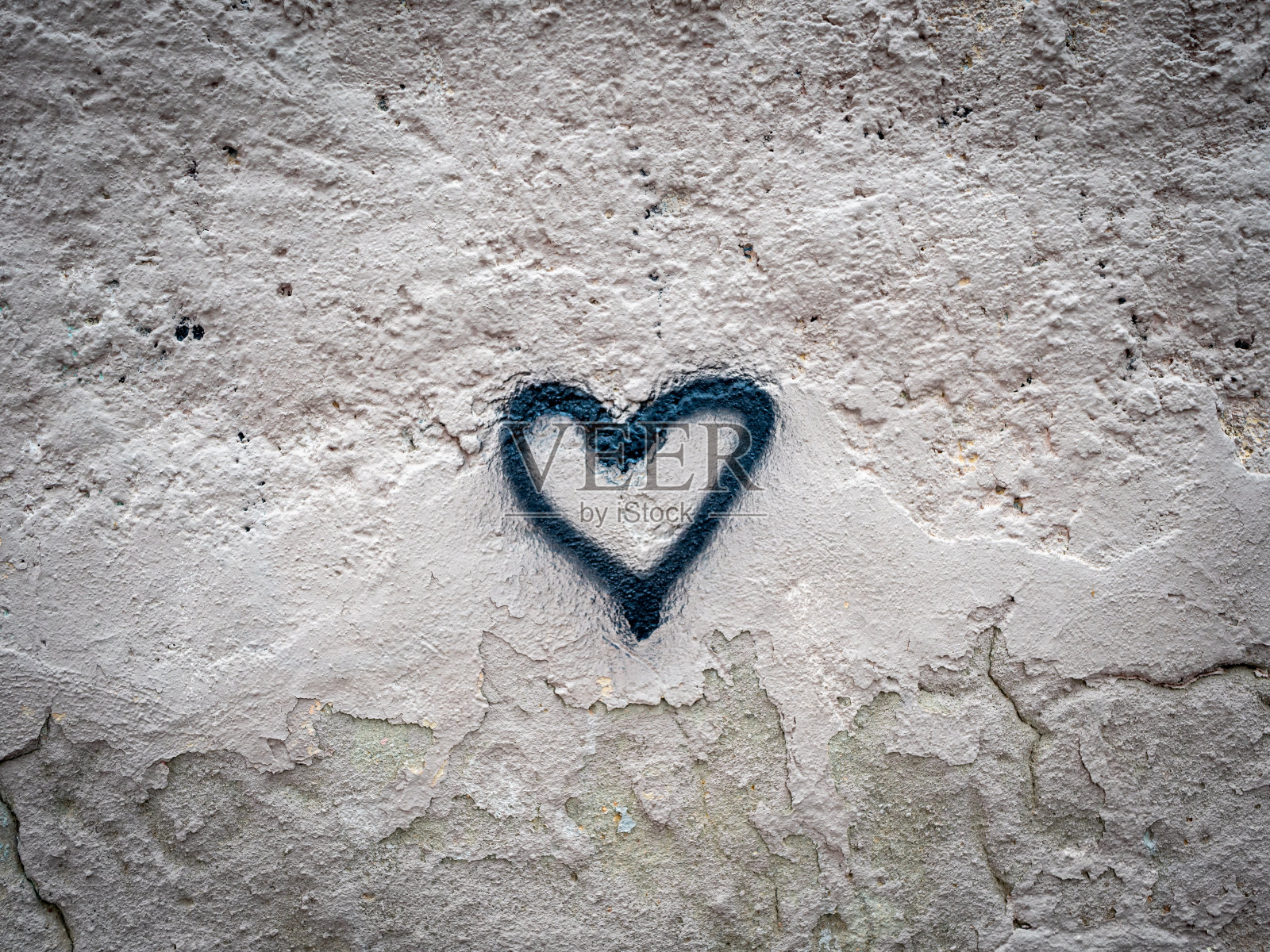 用黑色喷漆在破旧的墙上画的心形照片摄影图片