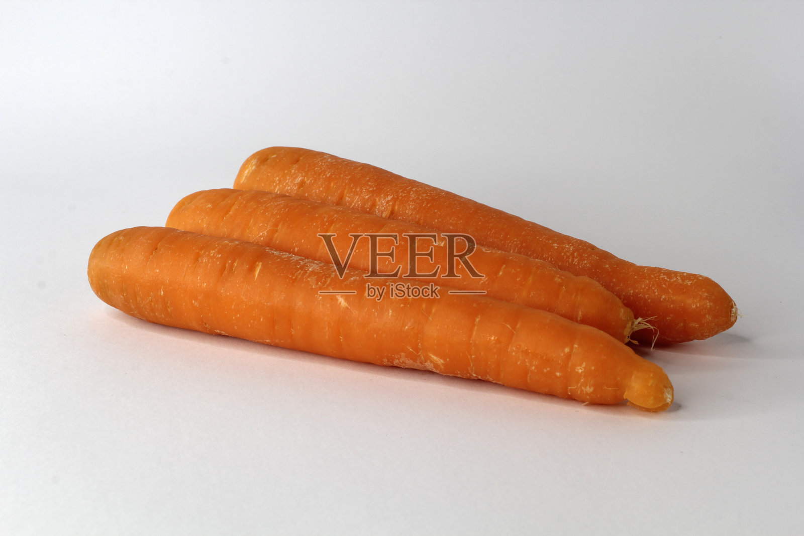 白色背景下的三根胡萝卜照片摄影图片