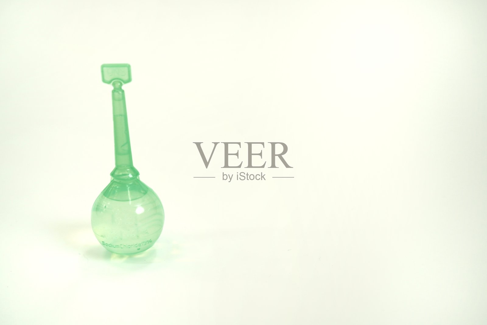 图示:白色背景上含有15%氯化钠溶液的小儿灌肠球，孤立。照片摄影图片