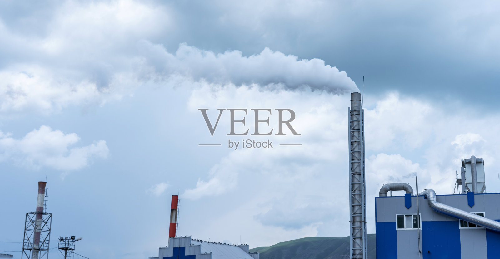 工厂烟囱和烟从烟囱里冒出来照片摄影图片