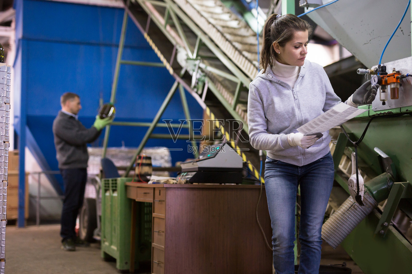 监视橄榄油榨油机传感器的妇女照片摄影图片